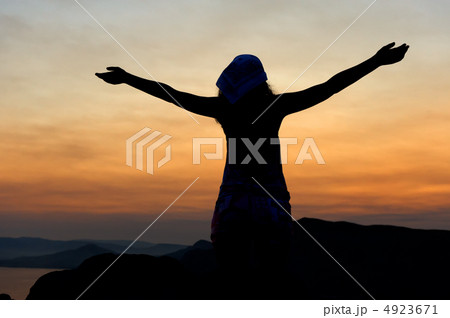 The woman on a mountain with open hands welcomes a decline. 4923671