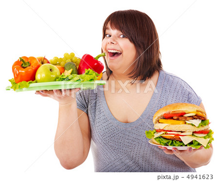 Woman choosing between fruit and hamburger. Woman choosing between fruit and hamburger. 4941623