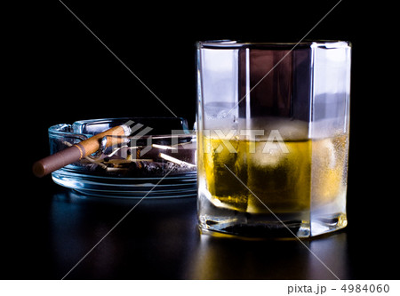 ashtray full of butts and glass of whiskey 4984060