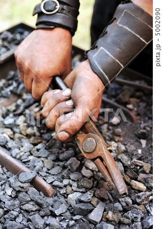 Detail of dirty hands holding pliers - blacksmith Detail of dirty hands holding pliers - blacksmith 5002090