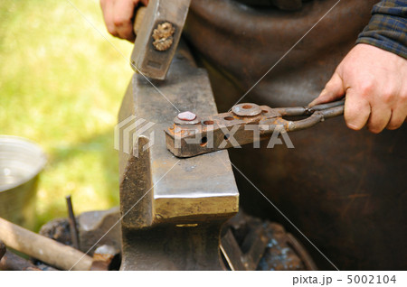 Blacksmith hammering hot steel on anvil Blacksmith hammering hot steel on anvil 5002104