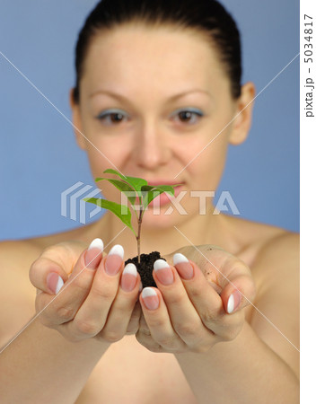 The woman holds in hands soil with a plant The woman holds in hands soil with a plant 5034817