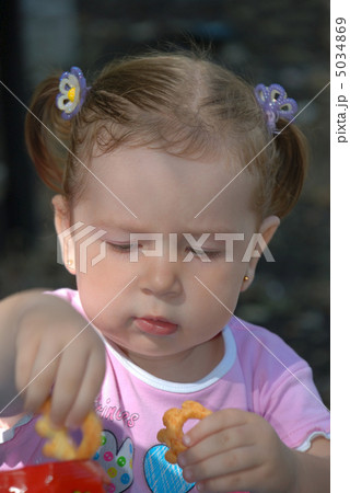 The girl taking cookie from a pack 5034869