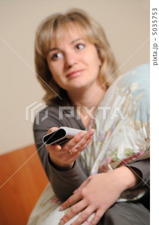 The woman with a television control panel. Selective focus 5035753