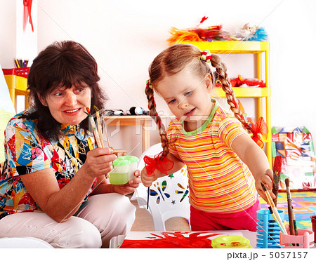 Child with teacher draw paints in playroom. 5057157