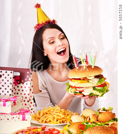Woman eating hamburger at birthday. 5057258