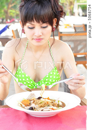 ビーチで食事するビキニの女性 5068754