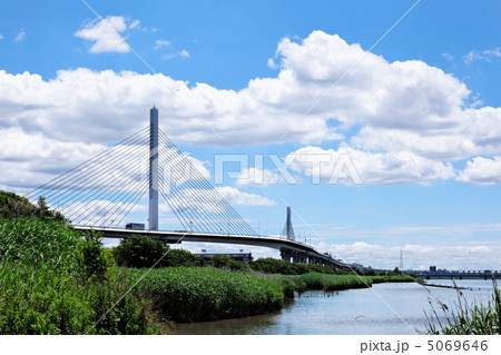 青空が広がる荒川の川原と綾瀬川に架かるかつしかハープ橋 5069646