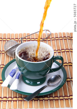 Pouring fresh tea into green cup Pouring fresh tea into green cup 5083727