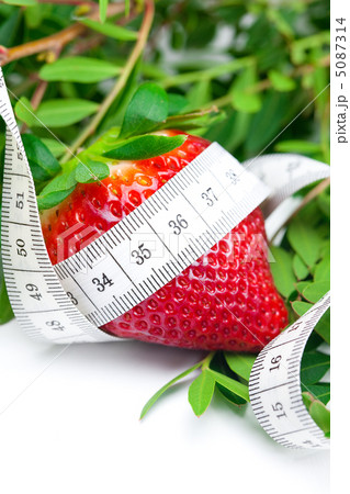 big juicy red ripe strawberries,herb and measure tape isolated o 5087314