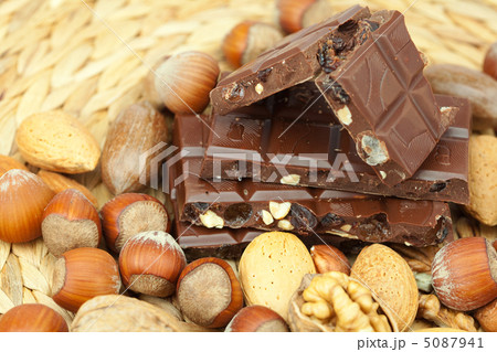 bar of chocolate and nuts on a wicker mat bar of chocolate and nuts on a wicker mat 5087941