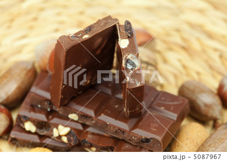 bar of chocolate and nuts on a wicker mat bar of chocolate and nuts on a wicker mat 5087967
