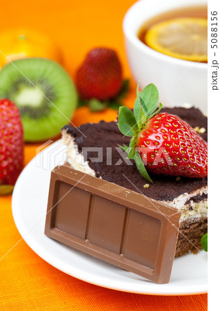lemon tea,chocolate, kiwi,cake and strawberries lying on the ora lemon tea,chocolate, kiwi,cake and strawberries lying on the ora 5088156