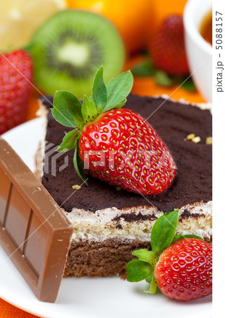 lemon tea,chocolate, kiwi,cake and strawberries lying on the ora 5088157
