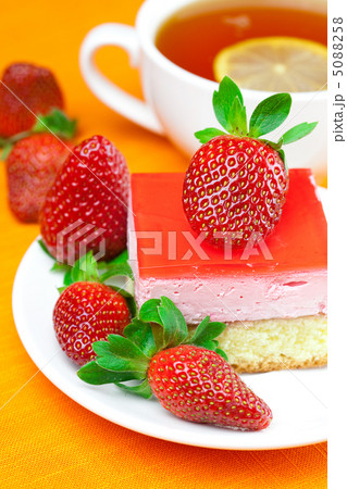 lemon tea, cake and strawberries lying on the orange fabric lemon tea, cake and strawberries lying on the orange fabric 5088258