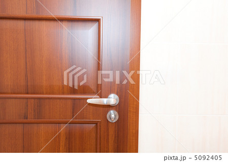 wooden door with a handle in a white room 5092405
