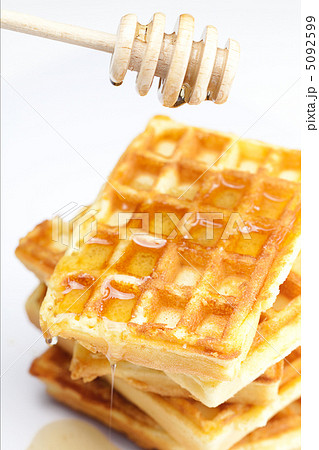 delicious Belgian waffles and stick to honey isolated on white 5092599