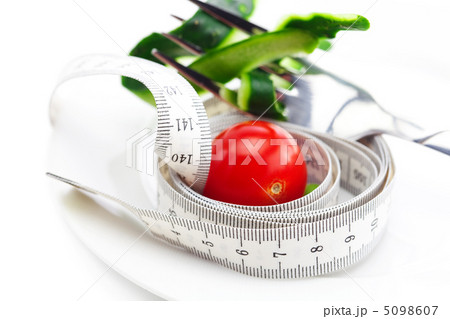 tomato,fork ,cucumber skin and measure tape on a plate isolated 5098607