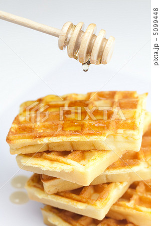 delicious Belgian waffles and stick to honey isolated on white 5099448