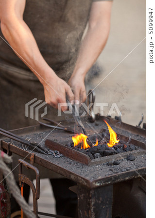 embers, fire, smoke, tools and the hands of a blacksmith embers, fire, smoke, tools and the hands of a blacksmith 5099947