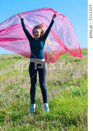 young beautiful woman jumping with tissue into the field against 5111324
