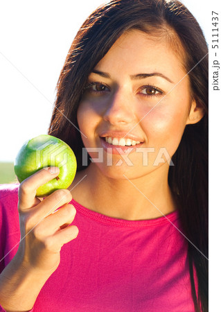 portrait of a beautiful young woman with apple  outdoor 5111437