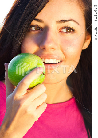 portrait of a beautiful young woman with apple  outdoor 5111438