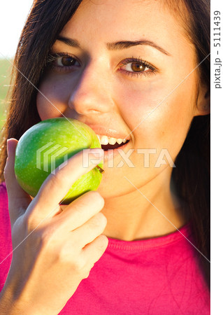portrait of a beautiful young woman with apple  outdoor 5111439