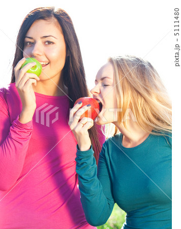 portret of two young beautiful woman with apple on the  sky back 5111480