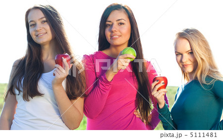 portret of three young beautiful woman with apple on the  sky ba 5111481