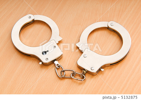 Metal handcuffs on the wooden background Metal handcuffs on the wooden background 5132875
