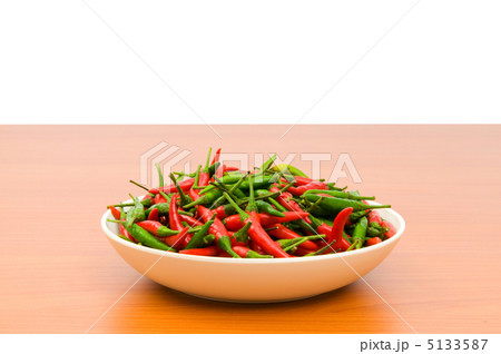 Hot peppers in the plate on wooden table 5133587