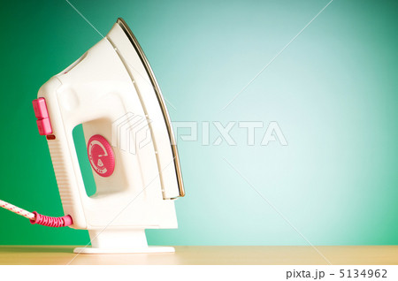 Modern electric iron against the colorful background 5134962