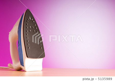 Modern electric iron against the colorful background 5135989