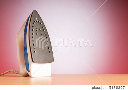 Modern electric iron against the colorful background 5136897