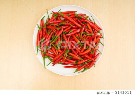 Hot peppers in the plate on wooden table 5143011