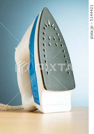 Modern electric iron against the colorful background 5144421