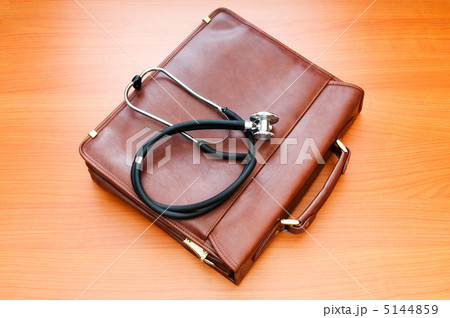 Doctor's case with stethoscope against wooden background Doctor's case with stethoscope against wooden background 5144859