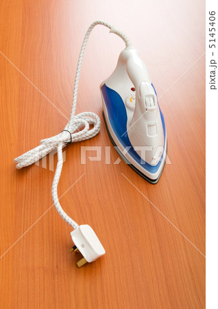 Modern electric iron on the wooden background Modern electric iron on the wooden background 5145406