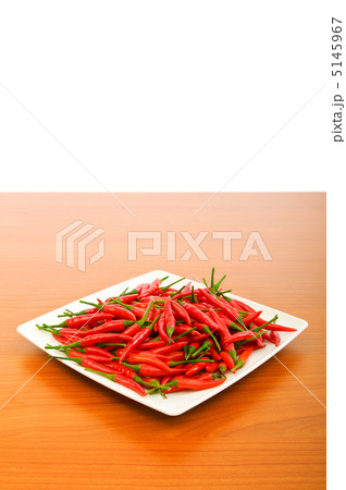 Hot peppers in the plate on wooden table Hot peppers in the plate on wooden table 5145967