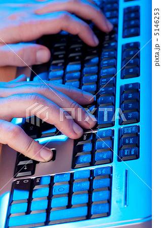 Two hands working on the silver keyboard 5146253