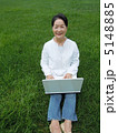 芝生の上でＰＣを楽しむシニア女性　縦　カメラ目線 5148885