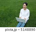 芝生の上でＰＣを楽しむシニア女性　横 5148890