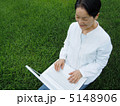芝生の上でＰＣを楽しむシニア女性　アップ 5148906
