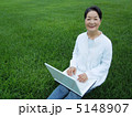 芝生の上でＰＣを楽しむシニア女性　カメラ目線 5148907