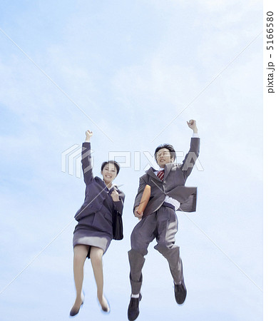 ガッツポーズをしてジャンプする男女の写真素材 ガッツポーズをしてジャンプする男女の写真素材