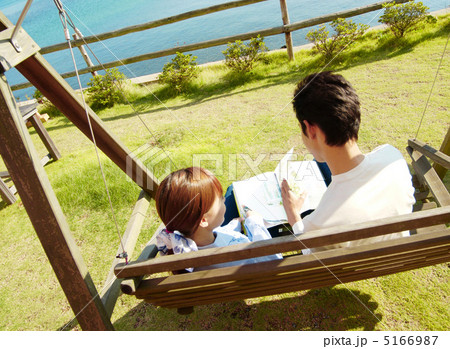 庭のブランコに座り本を読むカップル 庭のブランコに座り本を読むカップル 5166987