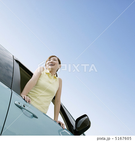 車の窓から乗り出す女性の写真素材