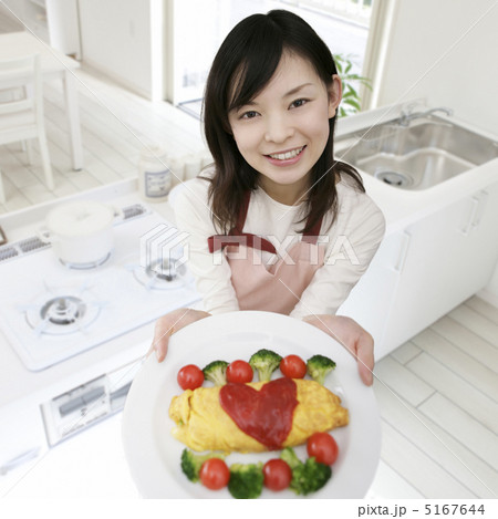オムレツをのせた皿を差し出す女性 5167644