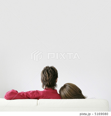ソファに座るカップルの後ろ姿の写真素材